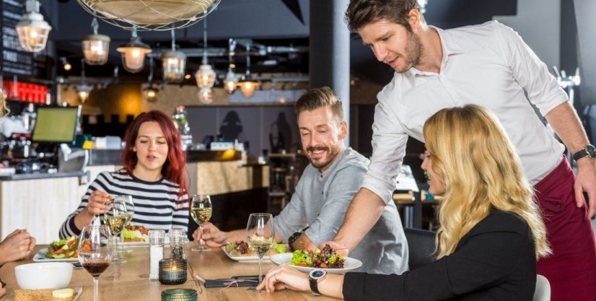 bigstock-Young-waiter-serving-food-to-c-115255127-1100x600-13